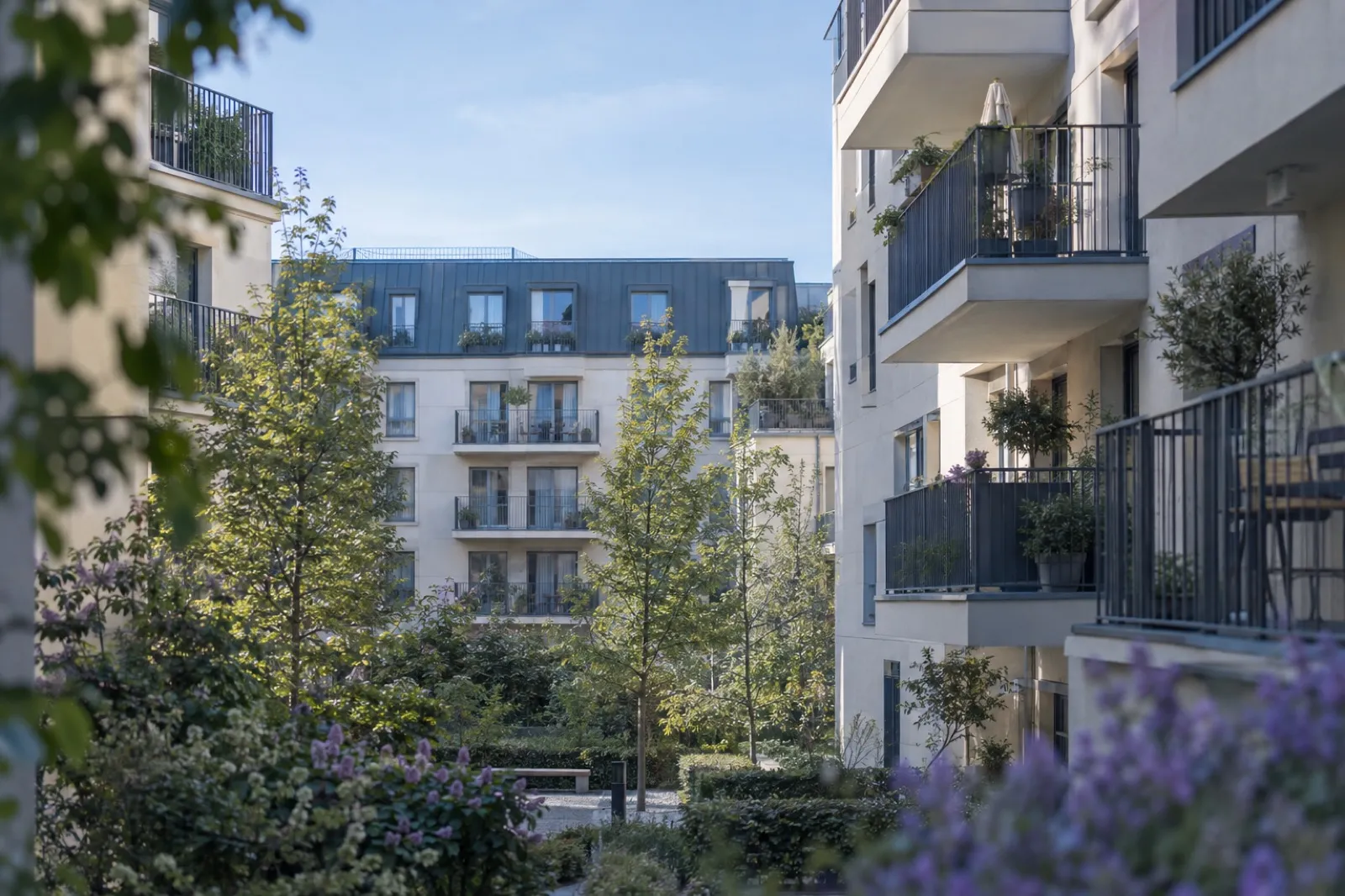 Résidence en copropriété avec balcons, arbres et jardin commun